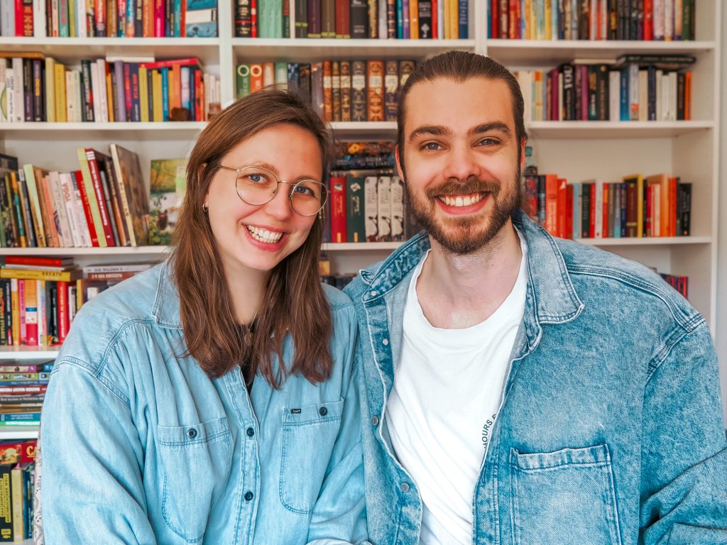 Rike und Julius sitzend vor einem Bücherregal – Jukes Studio Webdesign und Online-Marketing