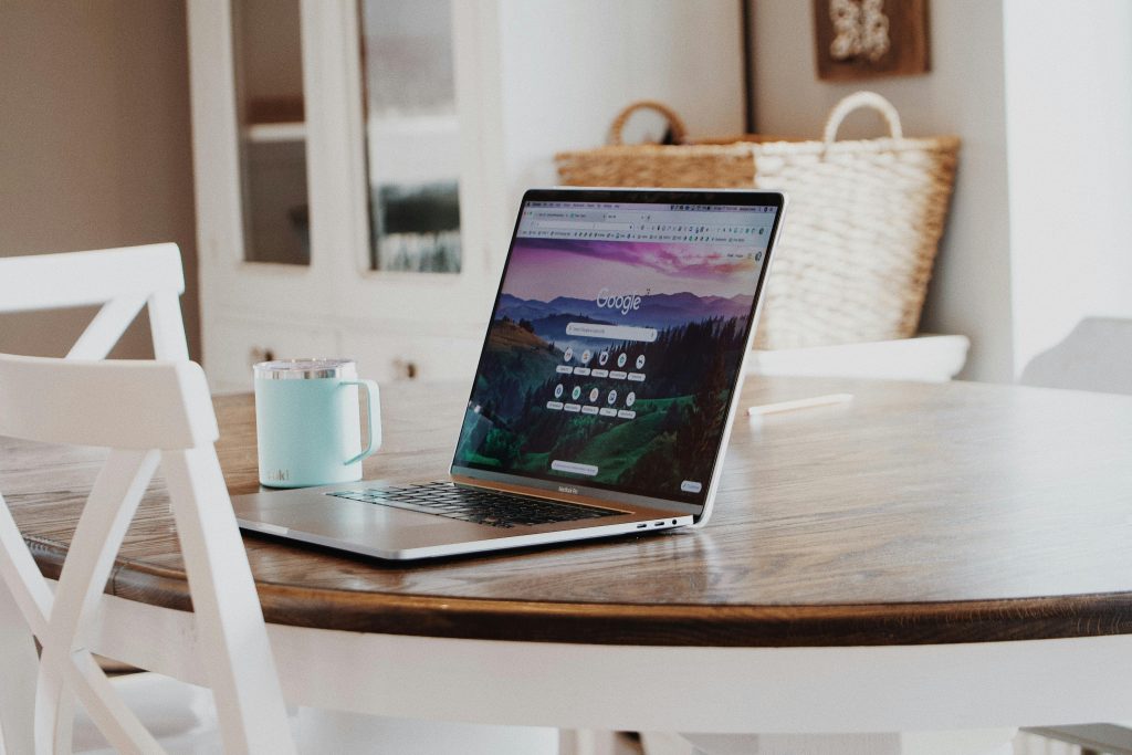 Offener Laptop auf Küchentisch mit Kaffeetasse daneben – Thema Website-Texte