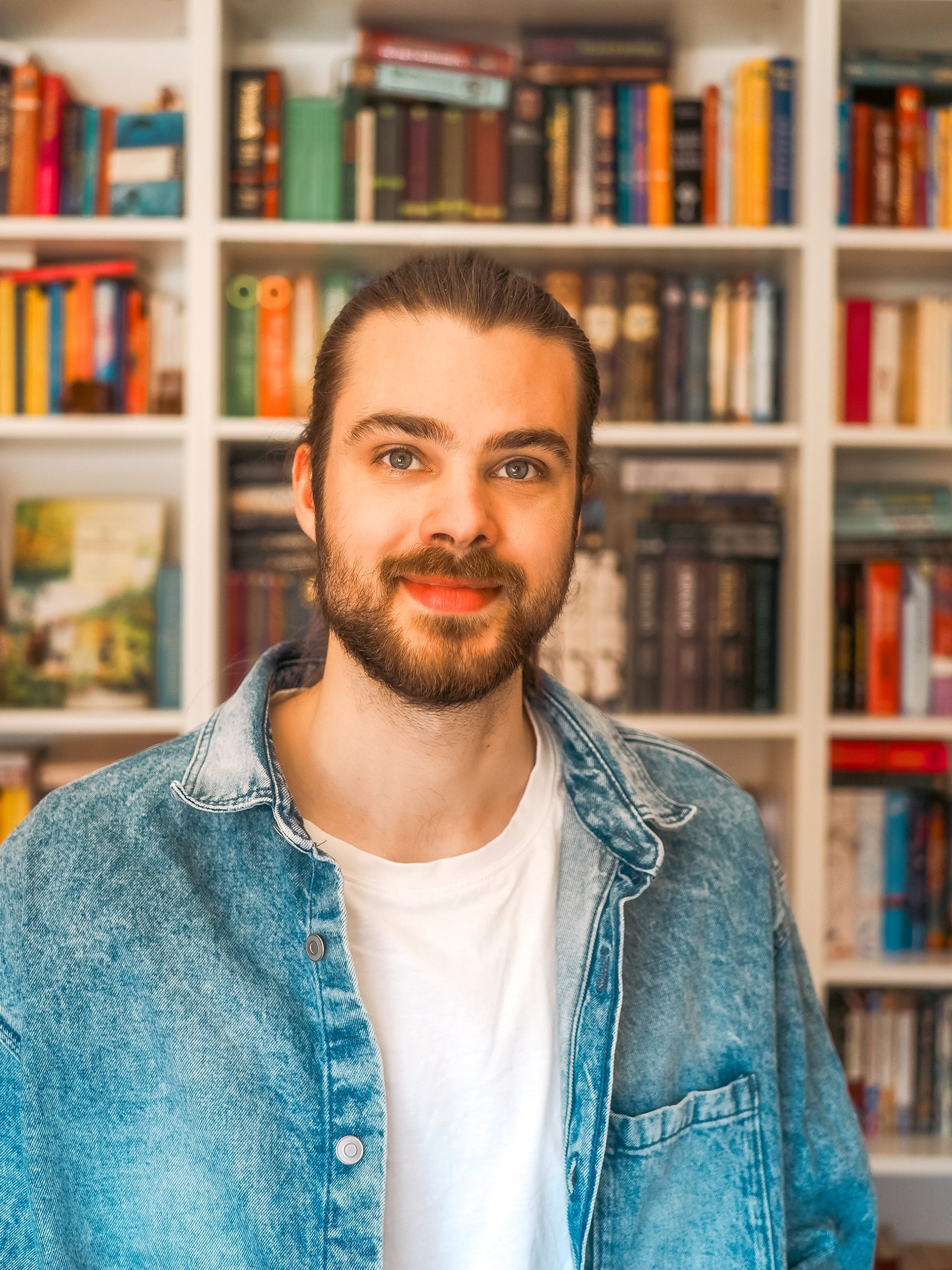 Teamfoto Jukes Studio Julius vor einem Bücherregal, Website erstellen lassen für dein Business